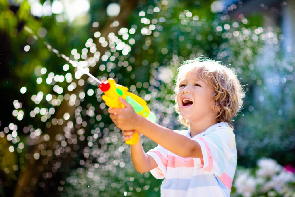 Kids Play With Water Gun Toy In Garden Outdoor Summer